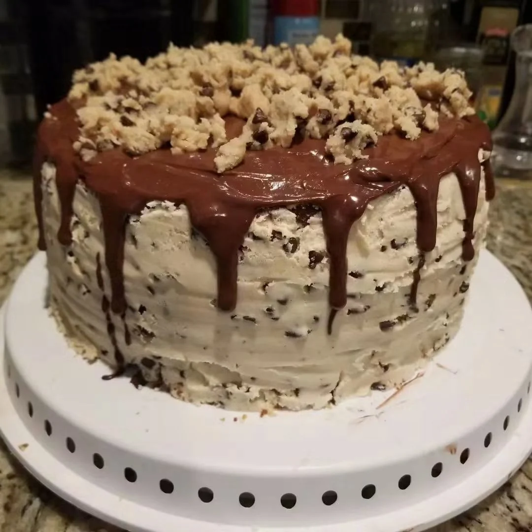 A cake with chocolate-chip frosting, chocolate drips and a crumbly topping