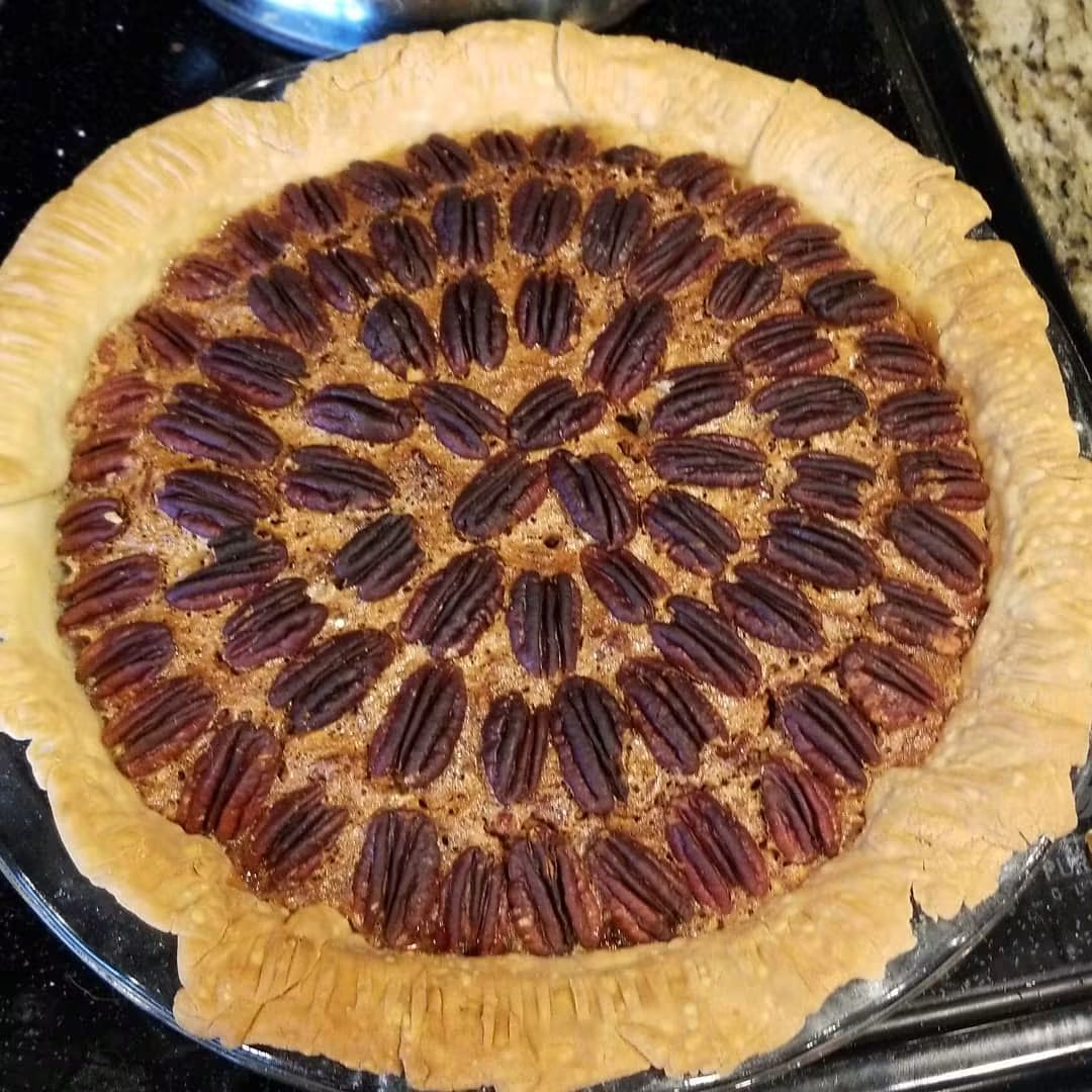 Golden pecan tart with concentric rings of pecan halves